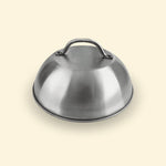 Cloche de cuisson en inox posée sur fond uni, accessoire pour plancha permettant de créer un effet four et de maintenir la chaleur.