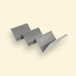 Support de maintien au chaud en inox, en forme de structure ondulée à trois niveaux, destiné à garder les aliments surélevés sur la plancha.