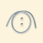 Tuyau de gaz blanc certifié butane/propane avec marquages bleus, accompagné de deux colliers de serrage métalliques, présenté sur fond uni clair.