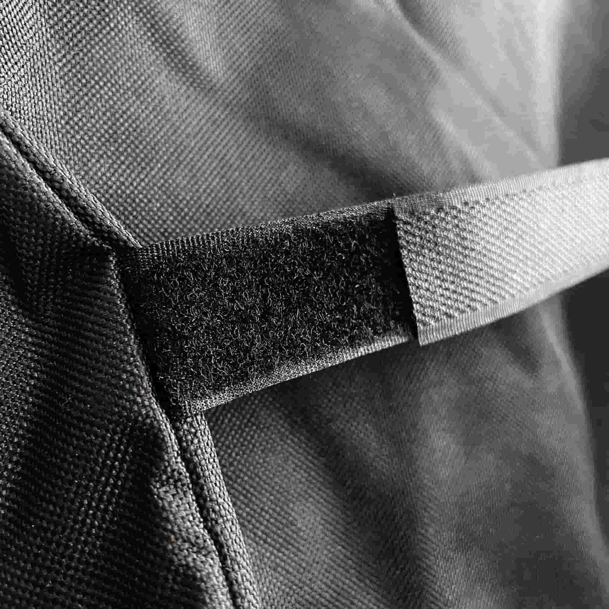 Gros plan sur la sangle à scratch d’une housse de protection Vivaplancha, montrant la texture du tissu et la fermeture velcro.