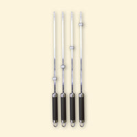 Lot de quatre brochettes longues en inox avec manche noir et bagues réglables, alignées sur fond beige.