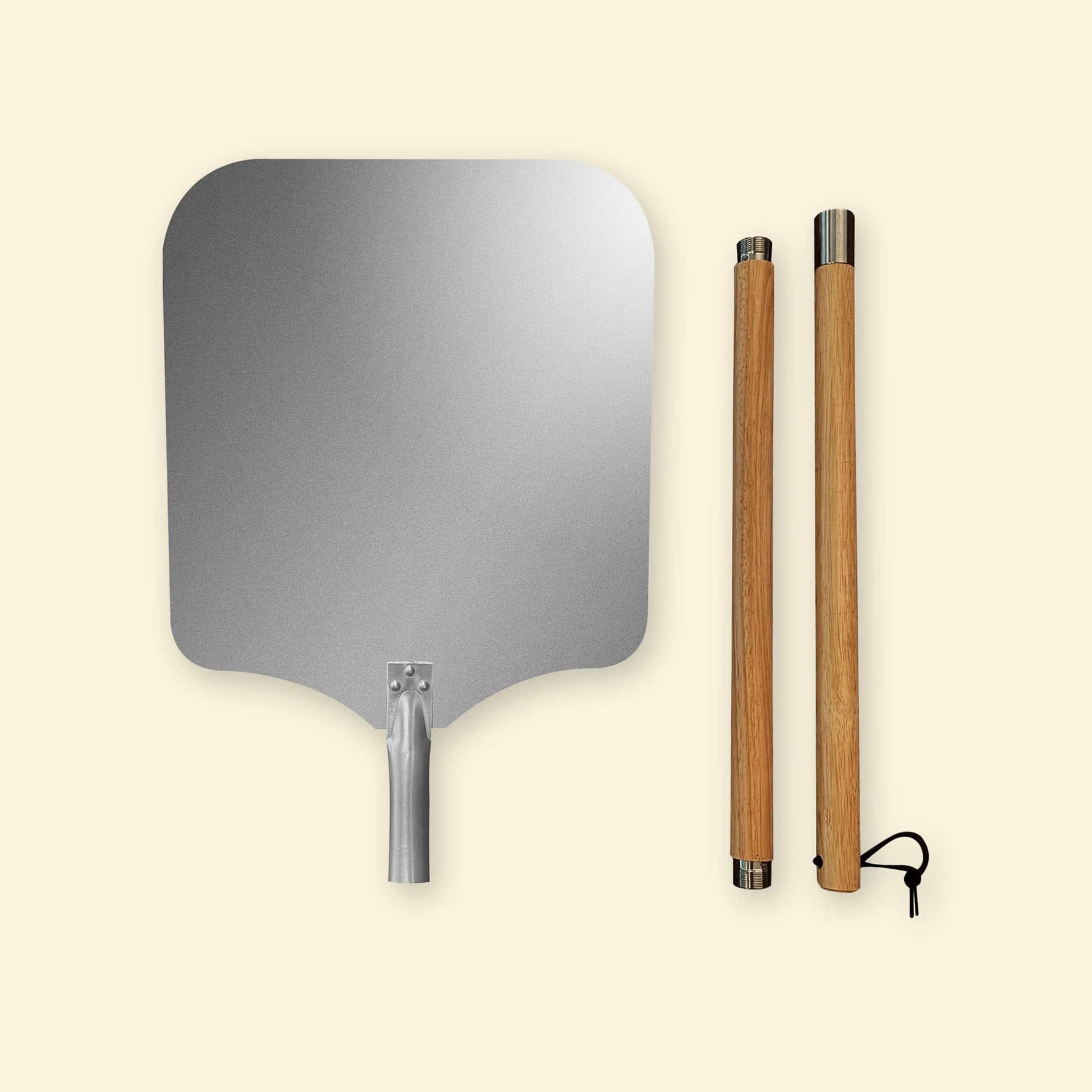 Pelle à pizza XL composée d’une large tête en aluminium et de deux manches en bois amovibles avec embouts métalliques, présentés côte à côte sur fond clair.