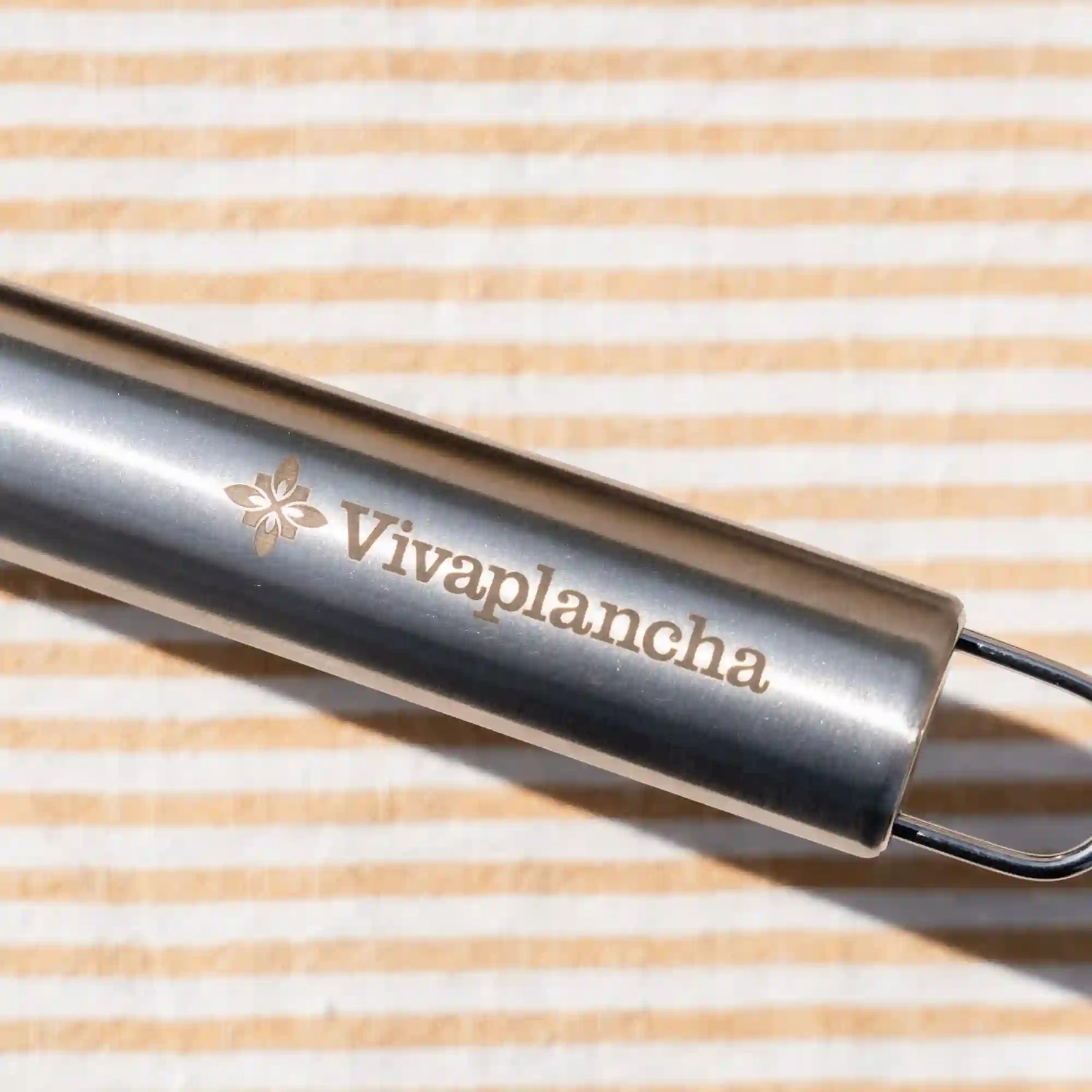 Gros plan sur le manche gravé Vivaplancha de la spatule à poisson